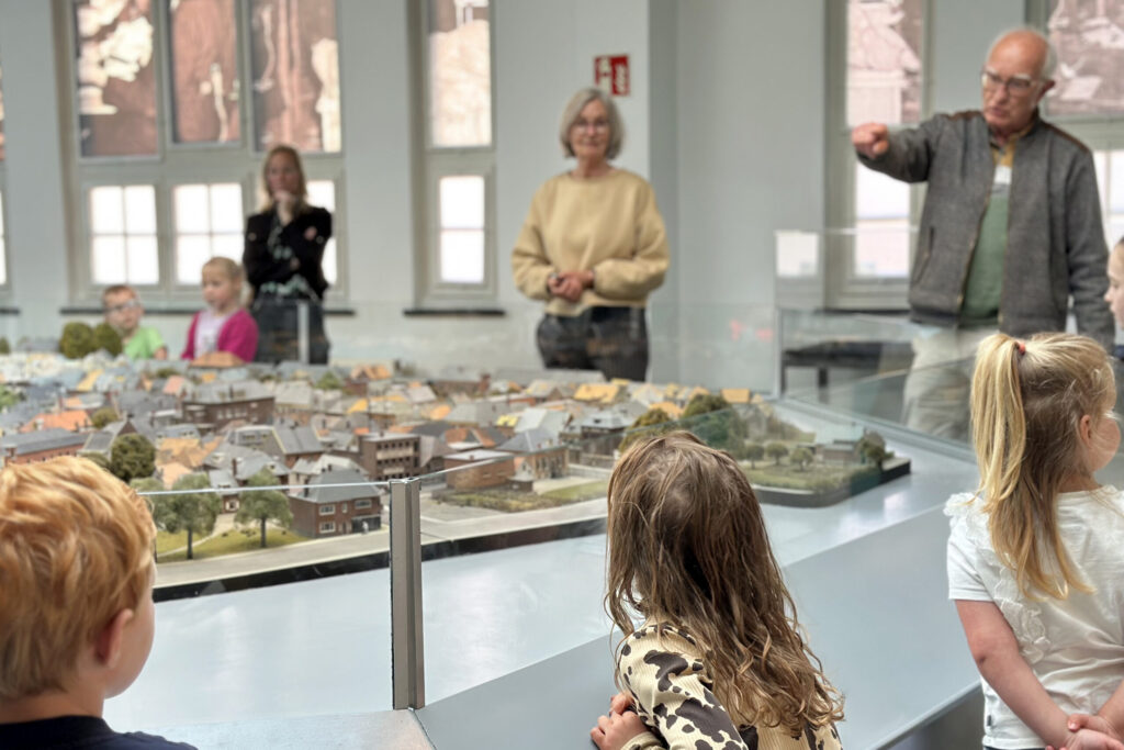 Schoolbezoek van kleuters met rondleider bij de maquette
